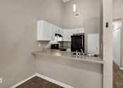 Thumbnail 3 of 17 - a kitchen with white cabinets and a counter top