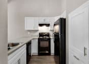 Thumbnail 2 of 17 - a kitchen with black appliances and white cabinets
