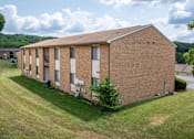 Thumbnail 16 of 19 - an image of a brick building with grass and trees