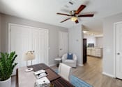 Thumbnail 8 of 17 - A living room with a white couch and a wooden coffee table.
