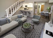 Thumbnail 7 of 17 - A living room with a staircase and a dining area.