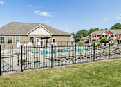 Thumbnail 39 of 65 - A house with a black fence and a pool in front.