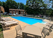 Thumbnail 12 of 16 - A pool surrounded by chairs and tables.