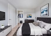 Thumbnail 7 of 17 - A bedroom with a large bed and a painting on the wall.