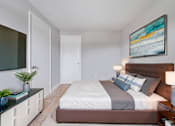 Thumbnail 6 of 17 - A bedroom with a large bed and a painting on the wall.