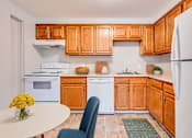 Thumbnail 3 of 38 - A kitchen with wooden cabinets and a white refrigerator.