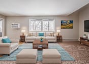 Thumbnail 2 of 38 - A living room with a white couch, a blue rug, and a painting on the wall.