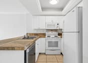 Thumbnail 2 of 14 - A kitchen with white cabinets and appliances.