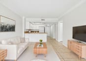 Thumbnail 3 of 14 - A living room with a white couch and a coffee table.