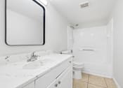 Thumbnail 8 of 14 - A white bathroom with a sink, mirror, and toilet.