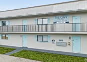 Thumbnail 10 of 14 - The Cove is a building with a balcony and blue doors.
