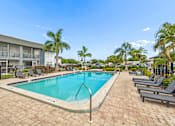 Thumbnail 19 of 23 - A pool surrounded by lounge chairs and palm trees.