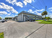 Thumbnail 15 of 16 - A sunny day at a parking lot with a white building in the background.