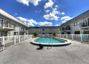 Thumbnail 13 of 16 - A swimming pool in a courtyard surrounded by buildings.