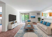 Thumbnail 4 of 18 - A living room with a white couch and a coffee table.