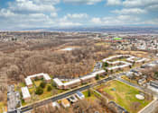 Thumbnail 25 of 25 - A large building complex with a green field in front.