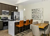 Thumbnail 11 of 20 - a kitchen and dining room with a table and chairs at Encore at Manchester, Novi, MI 48377