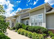 Thumbnail 5 of 35 - Building with bushes and a sidewalk at Encore Townhomes, Utica