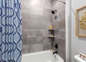 Thumbnail 36 of 38 - Bathroom with a shower curtain, a tub, a shelf, and a picture at Encore at West Valley, Michigan, 48386