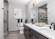 Thumbnail 32 of 38 - Bathroom with granite counter tops and a large mirror at Encore at West Valley, White Lake