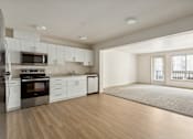 Thumbnail 23 of 32 - an empty kitchen and living room with white cabinets and stainless steel appliances
