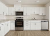 Thumbnail 22 of 32 - an empty kitchen with white cabinets and a stove and a microwave