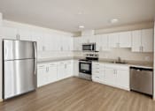 Thumbnail 21 of 32 - an empty kitchen with white cabinets and stainless steel appliances
