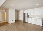 Thumbnail 24 of 32 - an empty kitchen with white cabinets and a stainless steel refrigerator