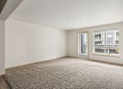 Thumbnail 28 of 32 - an empty living room with a large window and carpeting