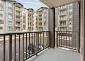 Thumbnail 31 of 32 - the view from the balcony of an apartment building with a black railing and a car