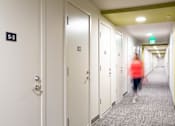 Thumbnail 32 of 32 - a woman walking down a hallway in a hotel room