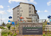 Thumbnail 2 of 32 - a sign that reads four corners an hin community with blue and white balloons on