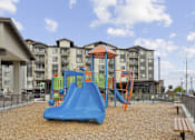 Thumbnail 19 of 32 - a playground at an apartment building with a blue slide