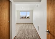 Thumbnail 24 of 25 - A hallway with a carpeted floor and a door on the left.