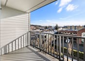 Thumbnail 33 of 46 - A balcony with a metal railing overlooks a town.