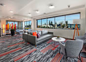 Thumbnail 8 of 25 - A modern waiting room with grey and red carpeting and comfortable seating.