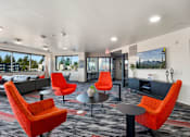 Thumbnail 6 of 25 - A room with orange chairs and a grey sofa.