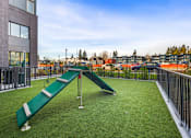 Thumbnail 17 of 25 - A playground with a green slide and a metal railing.