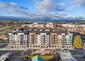 Thumbnail 2 of 46 - A large multi-story building with a parking lot in front.