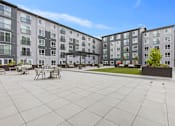 Thumbnail 39 of 66 - A large courtyard with a table and chairs surrounded by apartment buildings.