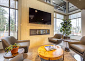 Thumbnail 4 of 32 - A living room with a flat screen TV mounted on the wall.