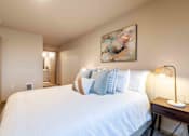 Thumbnail 17 of 32 - A bedroom with a large bed and a painting on the wall.