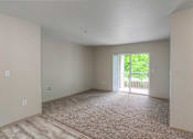 Thumbnail 10 of 15 - A room with a carpeted floor and a sliding glass door leading to a balcony.