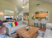 Thumbnail 3 of 15 - A living room with a white couch and a wooden coffee table.
