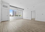 Thumbnail 7 of 46 - an empty living room with white walls and a window