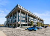 Thumbnail 46 of 46 - a large office building with cars parked outside