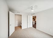 Thumbnail 20 of 43 - an empty bedroom with a ceiling fan and a door to a bathroom