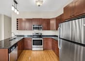Thumbnail 22 of 68 - an empty kitchen with wooden cabinets and stainless steel appliances