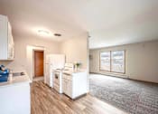 Thumbnail 1 of 31 - A kitchen with white appliances and a grey carpet.