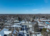 Thumbnail 22 of 27 - A snowy residential area with houses and a parking lot.